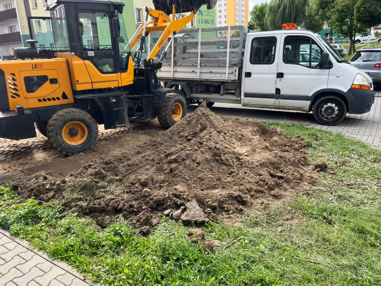 Ładowarka i samochód podczas prac ziemnych przy osiedlu